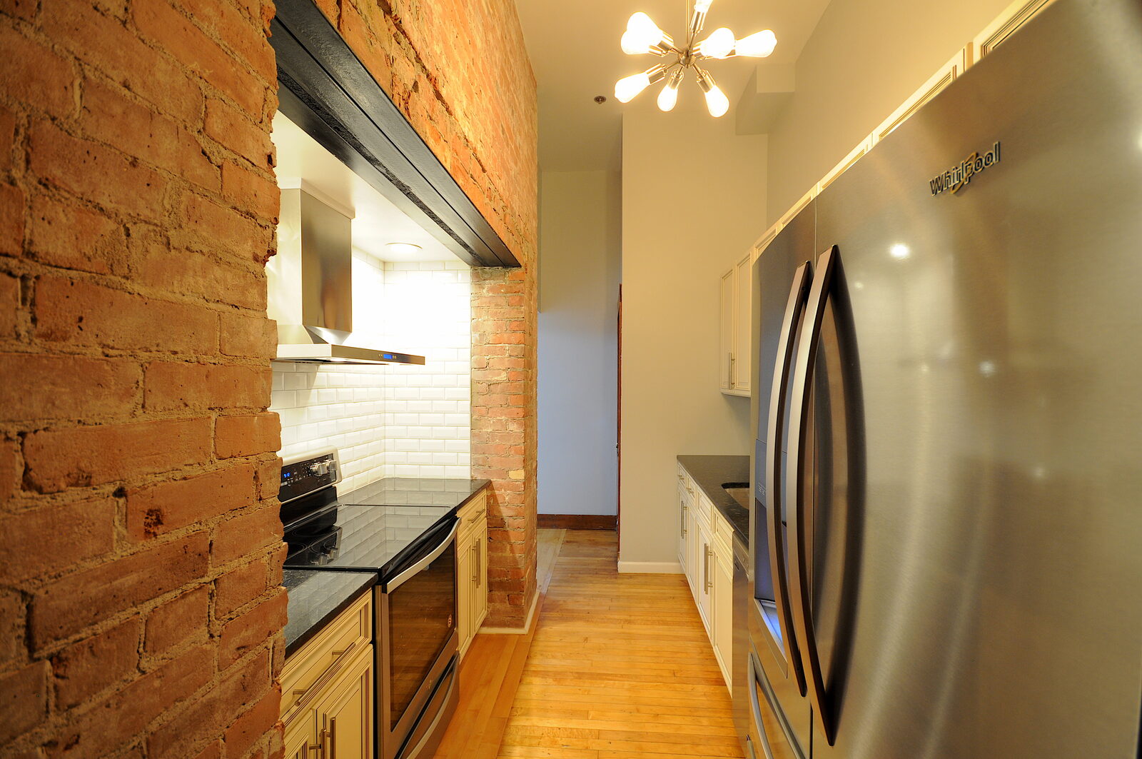 Exposed brick hallway with original archway leading to the kitchen