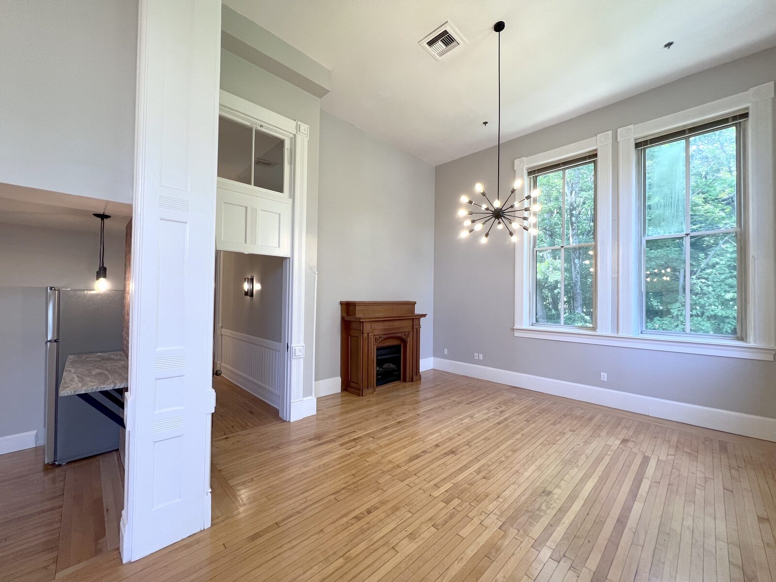 Living room with original hand-carved fireplace mantel