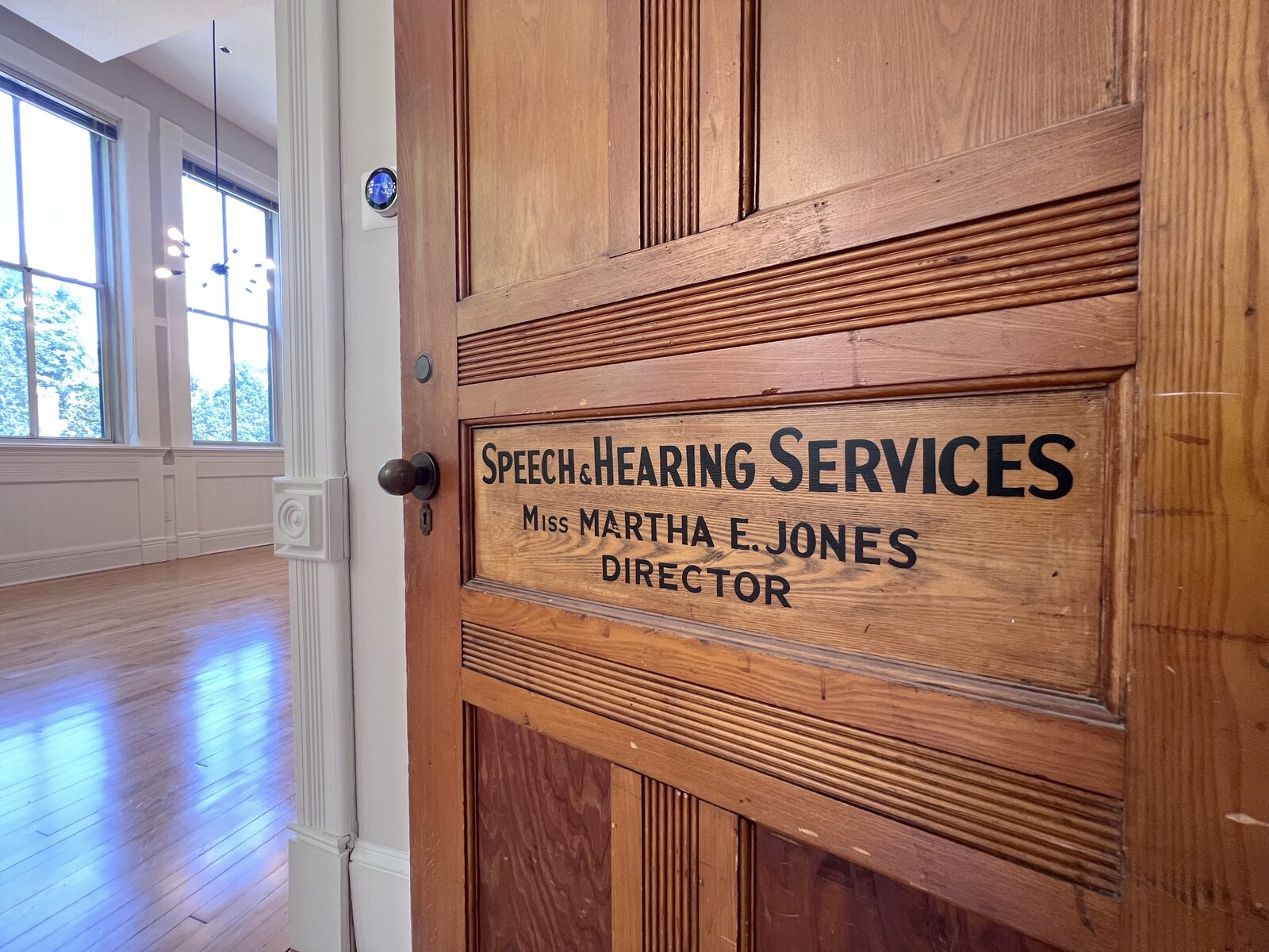 Original wood door reading 'Speech & Hearing Services, Miss Martha E. Jones, Director'
