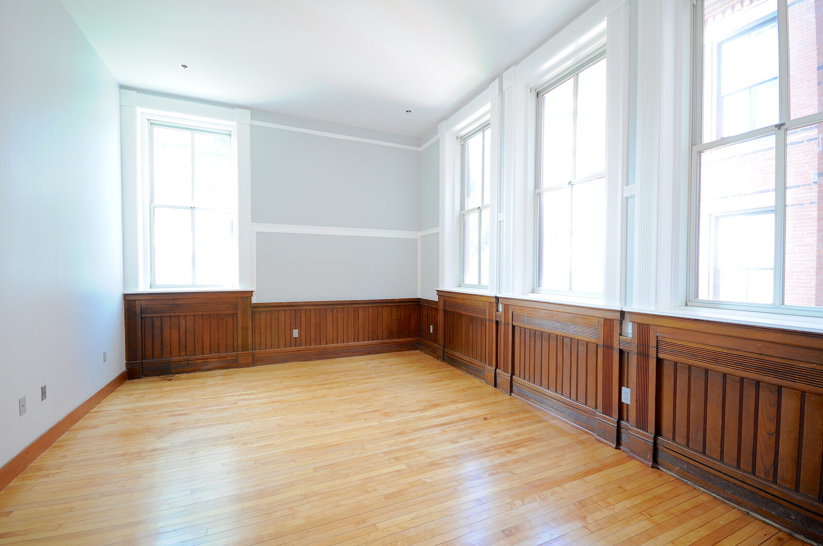 Sunlit residence at Hillside Place with original wood wainscoting and oversized historic windows